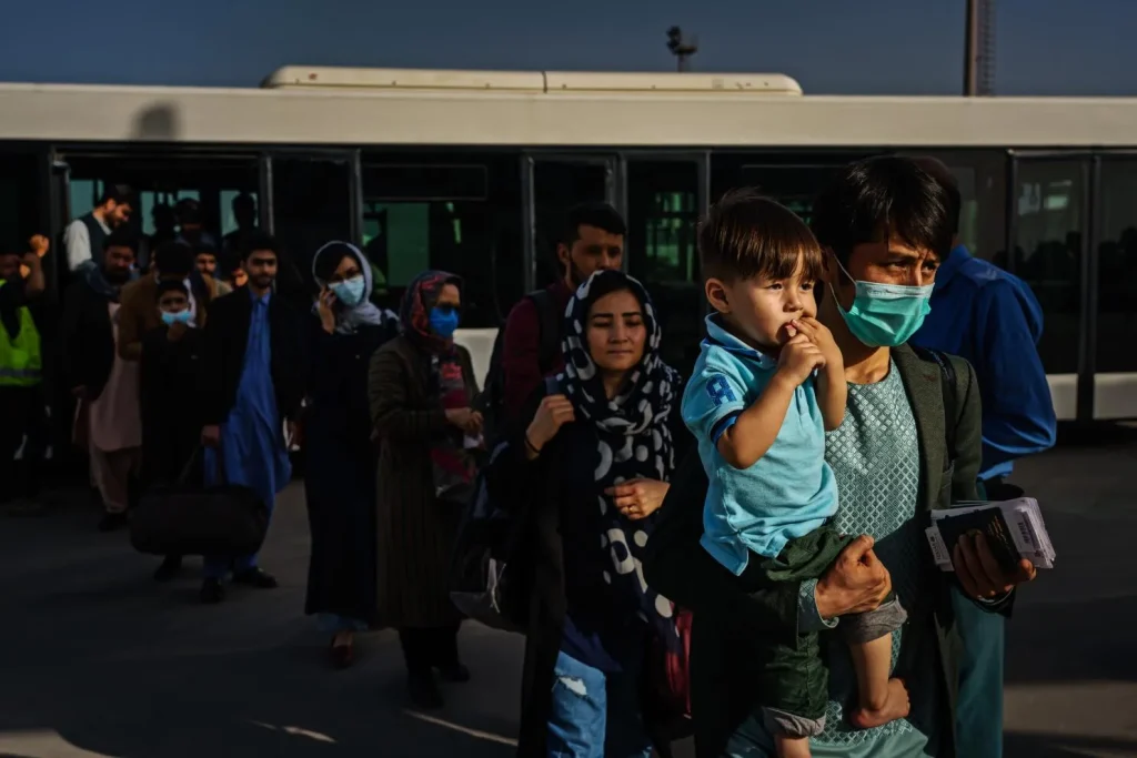 کدام کشور مهاجر افغان میپذیرد؟ (آپدیت 2025) 5 مهاجران افغان درحال پیاده شدن از اتوبوس
