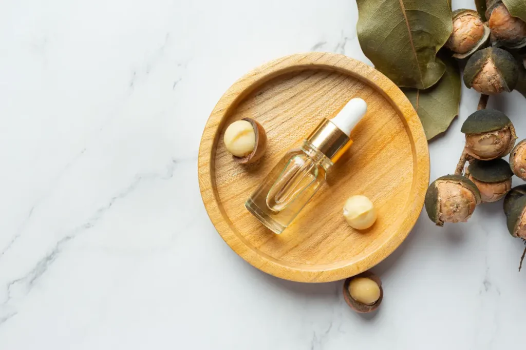 بهترین روغن برای از بین بردن چین و چروک صورت 3 یک شیشه روغن آرگان و تعدادی ماکادمیا کنار آن