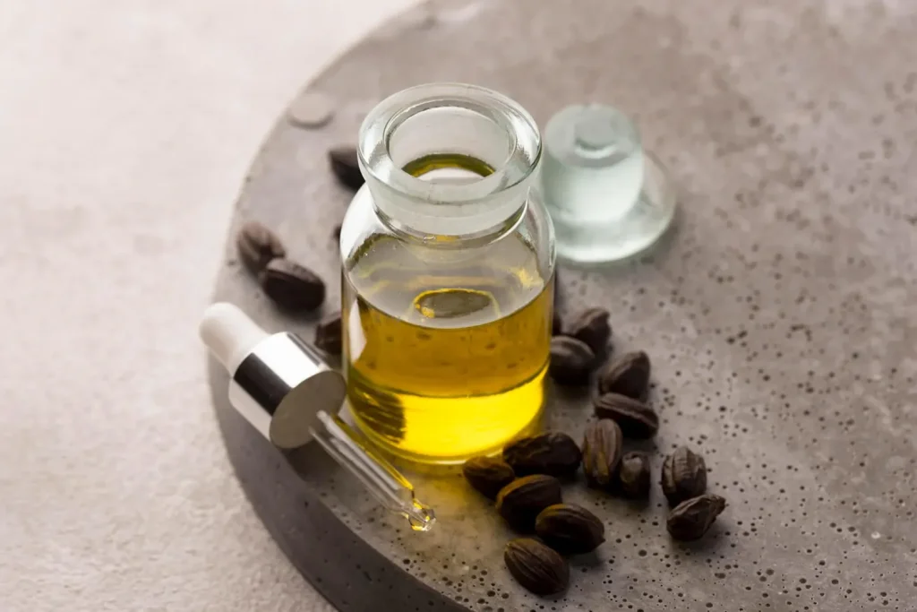 بهترین روغن برای از بین بردن چین و چروک صورت 4 یک شیشه روغن جوجوبا و تعدادی از دانههای این گیاه کنار آن