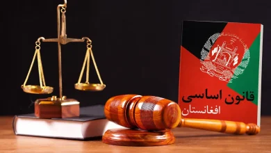 قانون اساسی افغانستان، همه آنچه باید بدانید 1 چکش قاضی روی میزی کنار گتاب قانون اساسی افغانستان