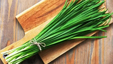 گندنه؛ خوشطعم، مغذی و ارزان 6 یک بسته گندنه روی تخته آشپزی چوبی